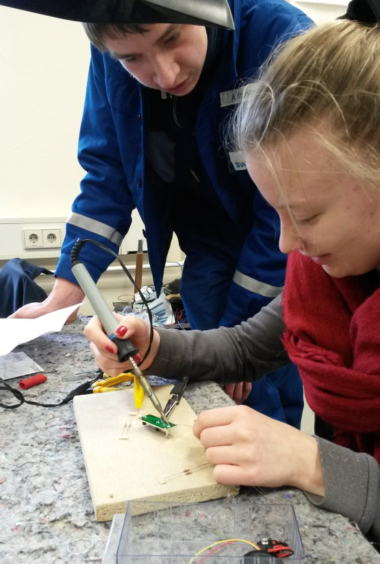 Angehende Elektroniker der WEMAG zeigen, wie Drähte gelötet werden.