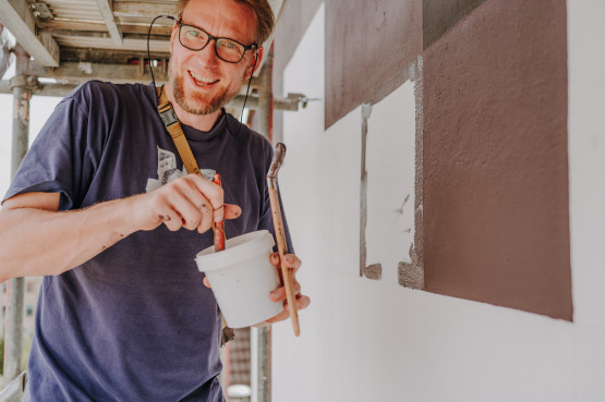 der Künstler Tino Bittner trägt die Farbe auf die Wand seines ersten Wandbildes 2024 auf.