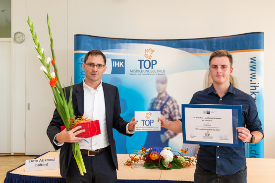 Der WEMAG-Ausbildungsleiter Frank Dumontie (li.) nimmt zusammen mit Domenik Kucz, Auszubildender Elektroniker für Betriebstechnik, die Auszeichnung entgegen
