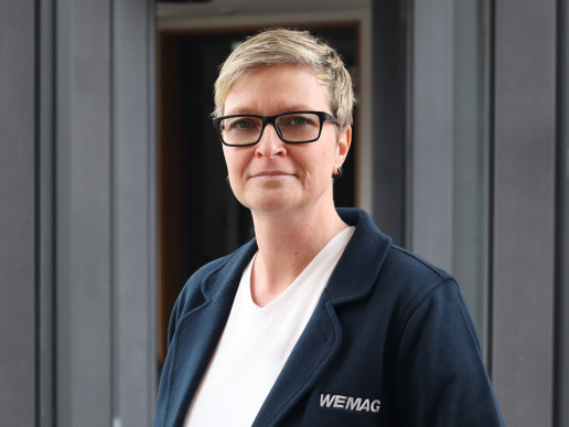 Ramona Raff, WEMAG-Mitarbeiterin, blickt in die Kamera vor hellem Hintergrund.