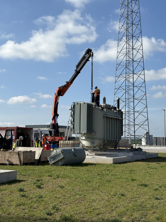 Ein Trafo wird mit Kran aufgeladen