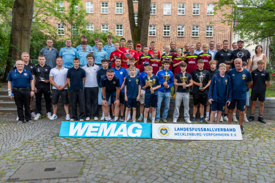 Alle Teilnehmer stehen als Gruppe zusammen und zeigen die Pokale.