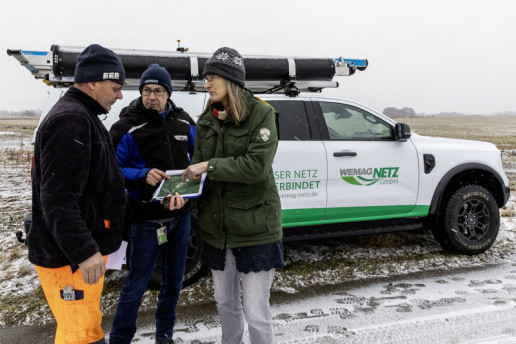 Die Mitarbeitenden besprechen sich für die Festlegung des Standortes. Sie halten eine Karte in den Händen.