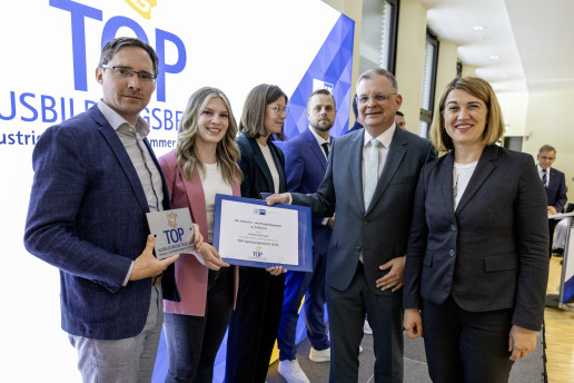 WEMAG-Gruppenleiter Ausbildung, Frank Dumontie, und die Dualstudierende Angelina Ziebell halten stolz die Urkunde und Plakette in die Kamera. 