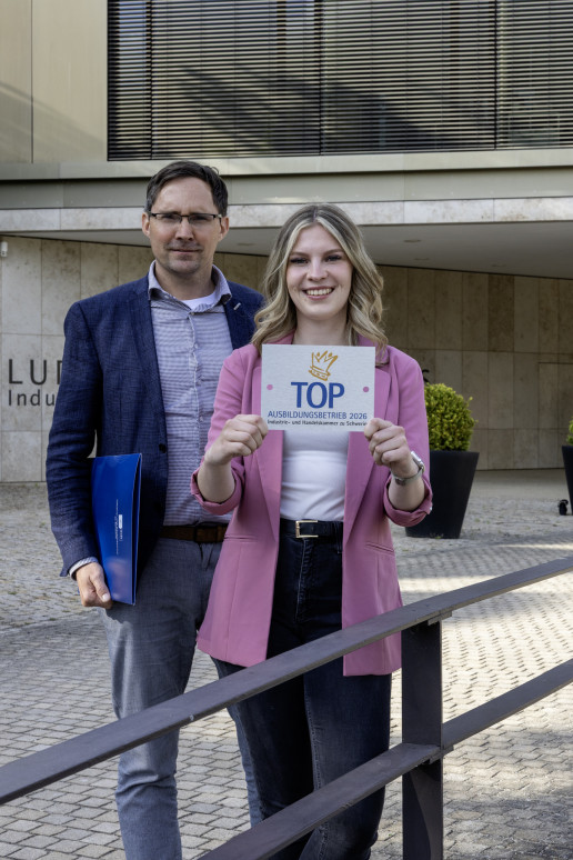 Frank Dumontie, WEMAG-Gruppenleiter Ausbildung, und die Dualstudierende Angelina Ziebell stehen vor der IHK zu Schwerin.