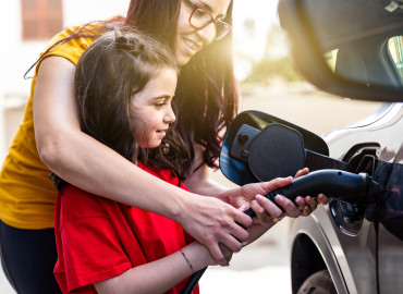 Mutter und Kind laden ihr Elektrogemeinsam