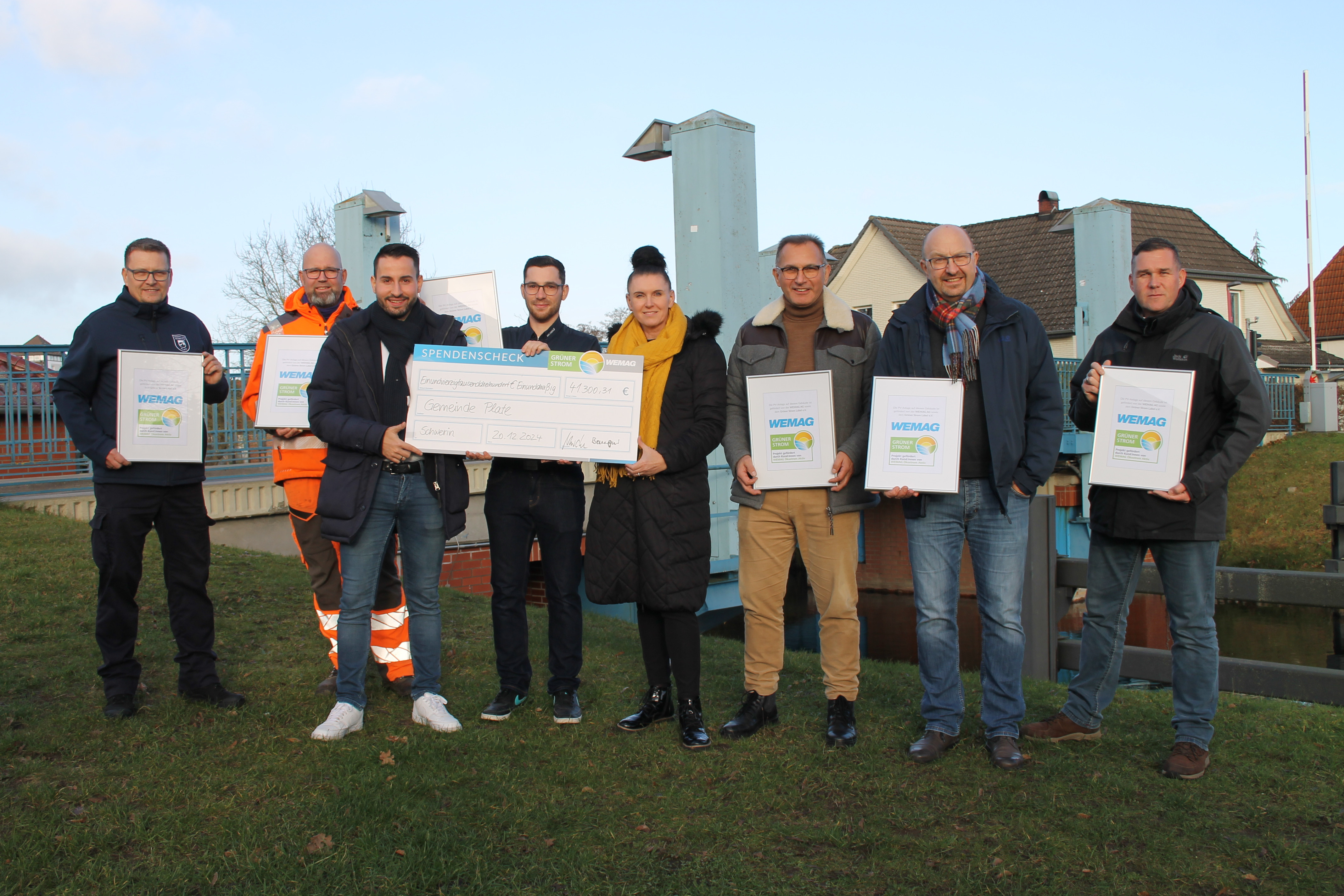 Alle Beteiligten auf einem Bild. Sie halten den Scheck in den Händen.