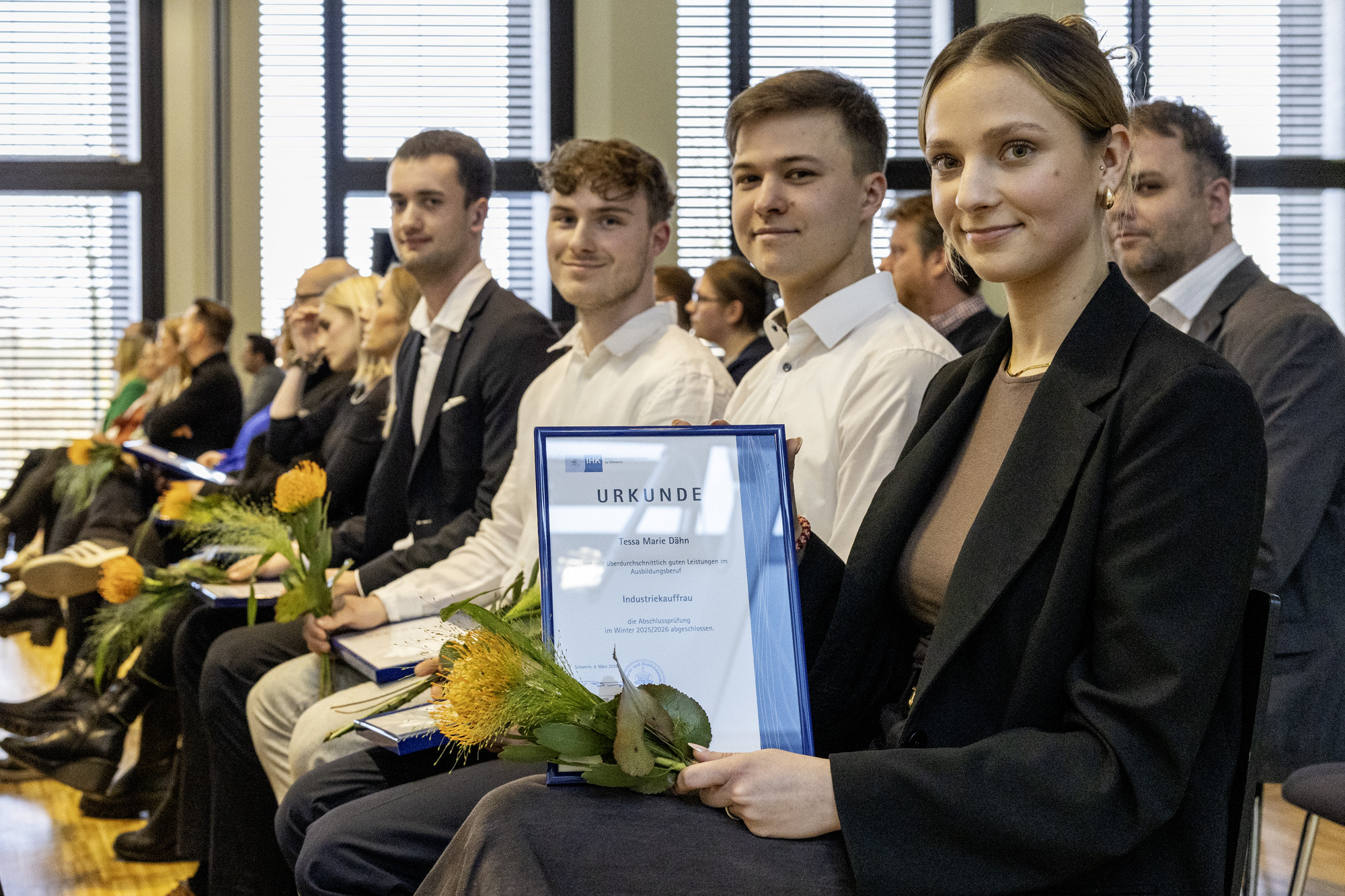 Die jungen Menschen zeigen stolz Ihre Urkunden in die Kamera.